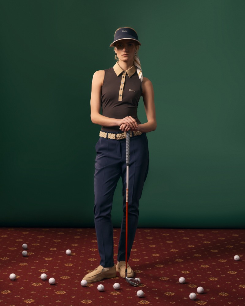 Modelka pozuje w brązowym polo damskim.